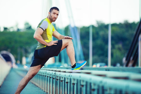 Early morning workout. Handsome man exercising on the bridge. Living healthy lifestyle.