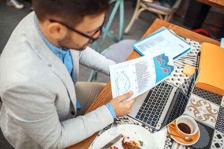 Businessman having breakfast and doing his work in cafe.の写真素材