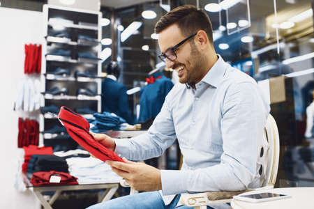 Portrait of handsome young man buying clothes in the store.の写真素材