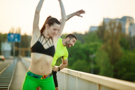 Early morning workout. Happy couple exercising on the bridge. Living healthy lifestyle.
