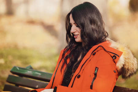 Beautiful young woman enjoying autumn in the park.の写真素材