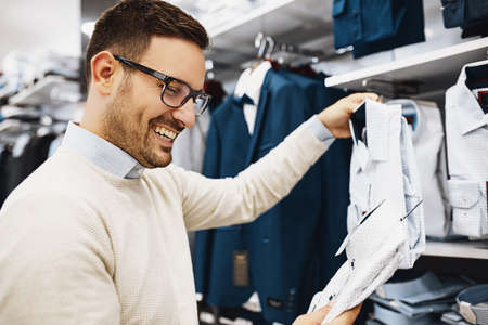 Portrait of handsome young man buying clothes in the store.の写真素材
