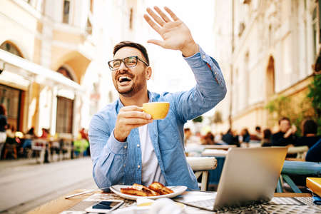 Man having breakfast and doing his work in cafe.の写真素材