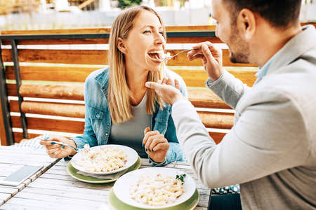 Young couple enjoying restaurant and eating pasta.の写真素材