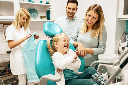 Dentist treating cute blonde child in his surgery.の写真素材