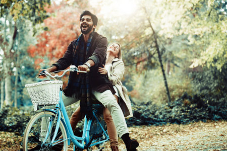 Young smiling couple enjoying fall in the park.