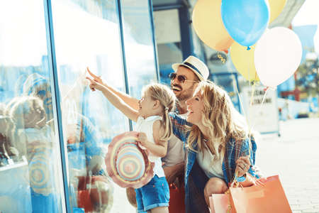 Young parents with four years old daughter enjoying shopping.の写真素材