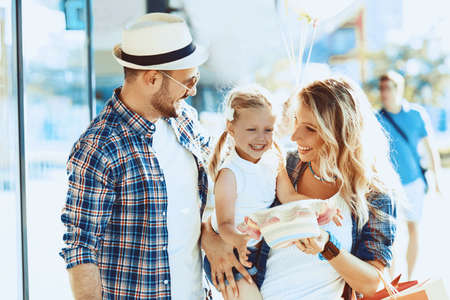 Happy family walking with shopping bags and baloons.の写真素材