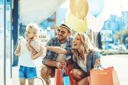 Young parents with four years old daughter enjoying shopping.の写真素材