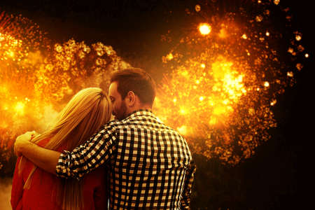 Young couple in love celebrating Christmas with fireworks outdoors.の写真素材