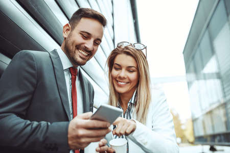 Businessman and businesswoman having informal meeting outdoors.の写真素材