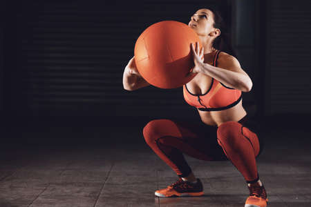 Young athlete woman exercing in garage using ball.の写真素材