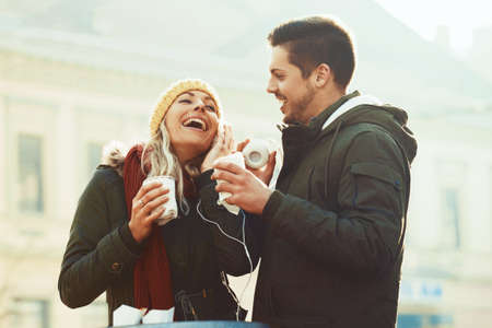 Young couple in love having hot drink outdoors.の写真素材