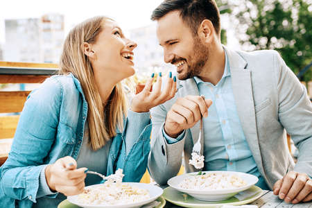 Young couple enjoying restaurant and eating pasta.の写真素材