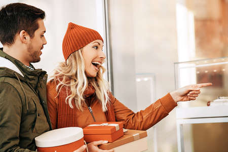 Young smiling couple enjoying Christmas shopping.の写真素材