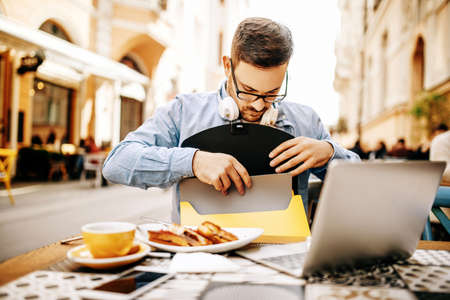 Man having breakfast and doing his work in cafe.の写真素材