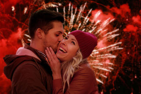 Young couple in love celebrating Christmas with fireworks outdoors. の写真素材