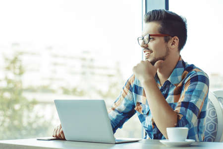 Man is doing his freelance job and drinking coffee.の写真素材