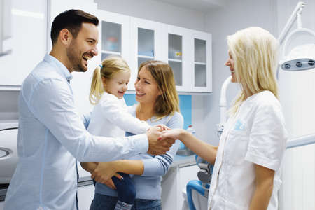 Dentist treating cute blonde child in his surgery. の写真素材
