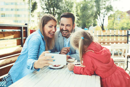 Happy family is enjoying pasta in restaurant.の写真素材