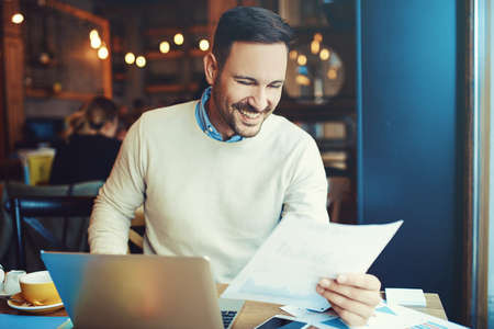 Businessman enjoying coffee and doing his freelance job.の写真素材
