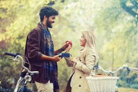 Young smiling couple enjoying fall in the park.の写真素材