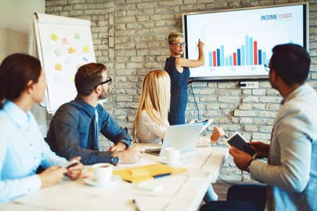 Creative business team working on project. Creative director is showing chart to the workers.の写真素材