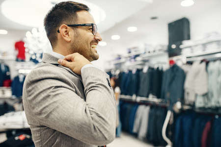 Portrait of handsome young man buying clothes in the store.の写真素材