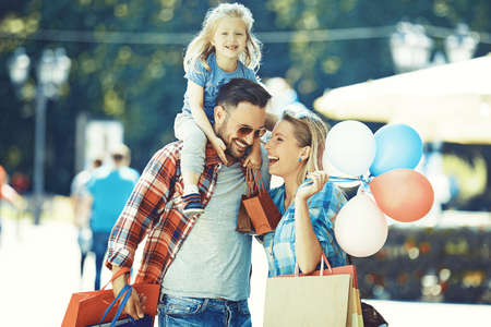 Happy family walking along the street with shopping bags.の写真素材
