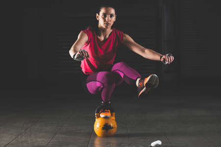 Young strong woman is training with kettlebell.の写真素材