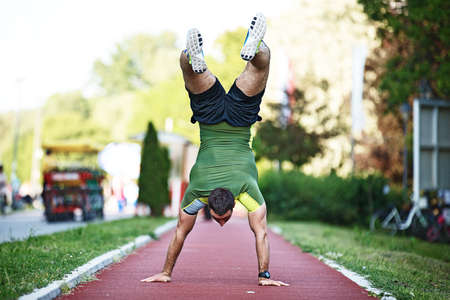 Young strong man is exercise outside and walking by hands.の写真素材
