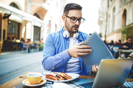 Businessman enjoying coffee shop and doing his freelance job.の写真素材