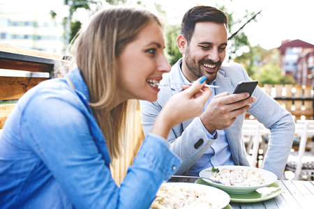 Happy couple is enjoying pasta in restaurant.の写真素材