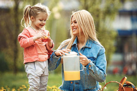 Mother and daughter enjoying picnic in the park.の写真素材