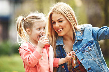 Mother and daughter enjoying picnic in the park.の写真素材