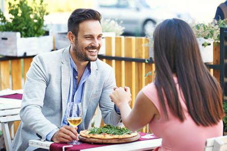 Love couple is enjoying pizza in restaurant.の写真素材