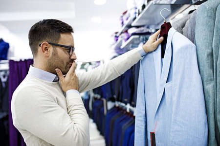 Portrait of handsome young man buying clothes in the store.の写真素材