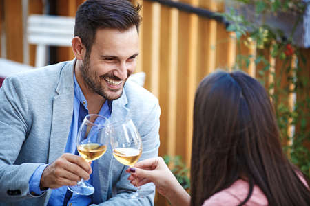 Love couple enjoying pizza and wine in a restaurant.の写真素材