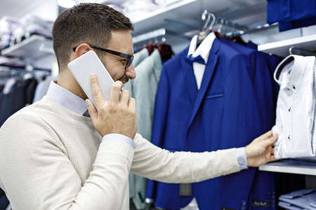 Portrait of handsome young man buying clothes in the store.の写真素材