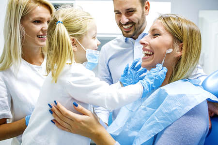 Dentist treating cute blonde child in his surgery. の写真素材