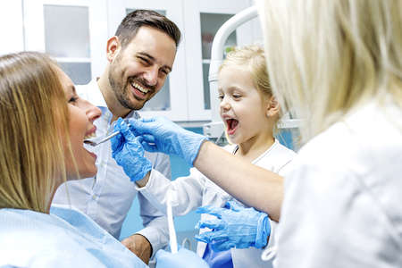 Dentist treating cute blonde child in his surgery. の写真素材
