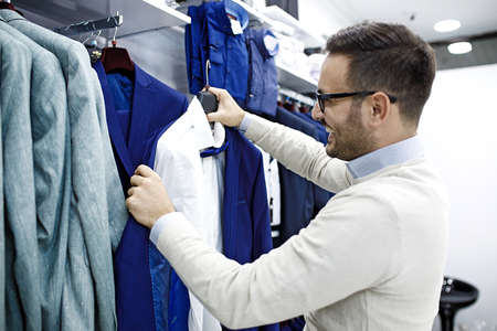Portrait of handsome young man buying clothes in the store.の写真素材