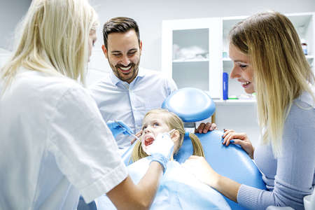Dentist treating cute blonde child in his surgery. の写真素材