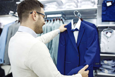 Portrait of handsome young man buying clothes in the store.の写真素材