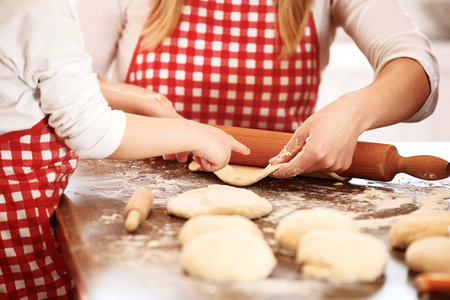 Mum and daughter spending time together making dough. 