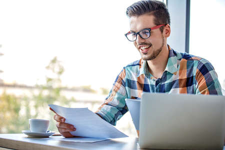 Man is doing his freelance job and drinking coffee.の写真素材