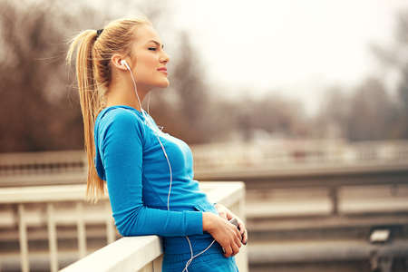 Young blonde woman is relaxing after exercise.の写真素材