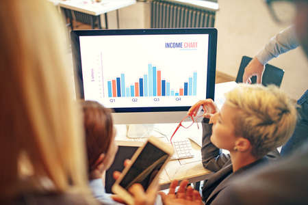 Creative business team working on project. Creative director is showing chart to the workers.の写真素材
