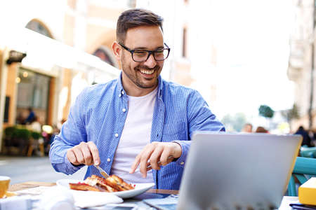 Businessman having breakfast and doing his work in cafe.の写真素材