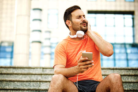 Man is listening music and relaxing after jogging.の写真素材
